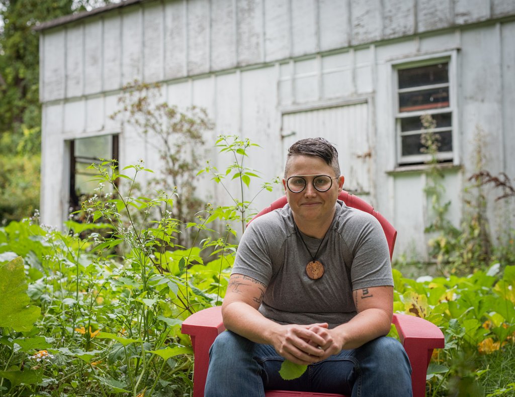 image of Grover sitting on a red char in front of white barn